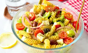 En härlig grekisk pastasallad med fusilli, körsbärstomater, fetaost, oliver och rödlök. Perfekt för en lätt lunch eller middag.