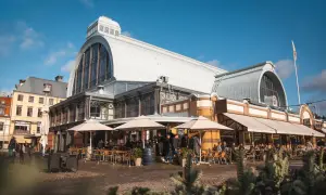 Fasaden på Saluhallen i Göteborg med uteserveringar. Perfekt för att uppleva saker att göra i Göteborg.