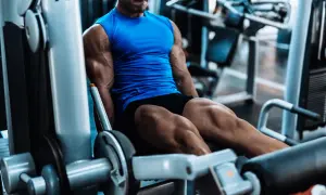 Muskulöser Mann trainiert Beine an einem Gerät. Perfekt für intensives HIIT Training zuhause oder im Gym.