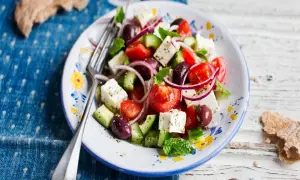 En fräsch grekisk sallad med fetaost, tomater, gurka, oliver och rödlök, perfekt med en lätt grekisk sallad dressing.