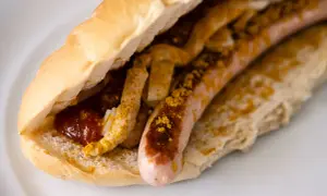 Ein Brötchen mit Wurst, Ketchup und Currypulver, wie bei einem bosna rezept.