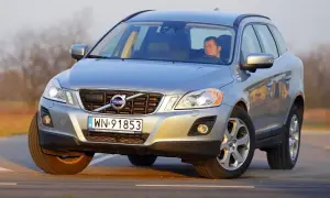 Srebrny Volvo XC60 z kierowcą na drodze. Sprawdź aktualną volvo xc60 cena i oferty.
