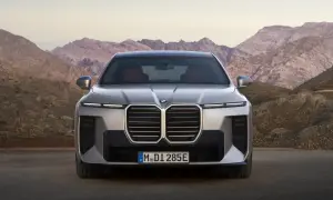 Nowe BMW Serii 7, z imponującym grillem i nowoczesnymi światłami, prezentuje się na tle górskich krajobrazów. Sprawdź jego BMW 7 cenę.