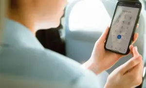 Osoba w samochodzie wybiera numer na telefonie, pokazując, jak działa voip.