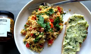 Frischer Couscous-Salat mit Tomaten, Gurken und Kräutern, serviert mit Kräuterbutterbrot. Ein tolles Couscous-Salat-Rezept für den Sommer.