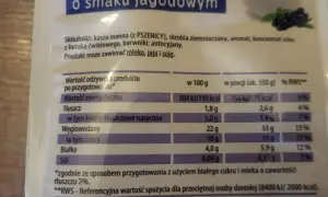 Opakowanie kaszy manny o smaku jagodowym z tabelą wartości odżywczych i ilustracją jagód.