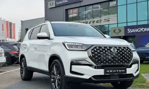 Biały SsangYong Rexton na tle salonu samochodowego. Elegancki SUV gotowy na przygodę.