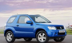 Niebieski Suzuki Grand Vitara 2005 na tle nieba z chmurami i samolotem.