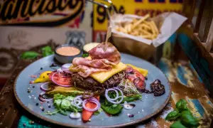 Pyszny burger z bekonem, serem i warzywami. Prawdziwe niebo w gębie w Karpaczu! Do tego frytki i sosy.