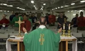 Kapłan prowadzi nabożeństwo, a wierni stoją z modlitwą. To obraz różnicy między religijnością a prawdziwą relacją z Bogiem.