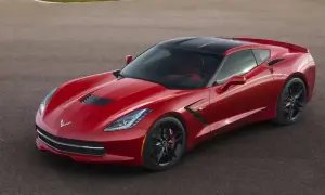Czerwony Chevrolet Corvette Stingray z czarnym dachem na torze wyścigowym.