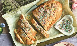 Ciambella romagnola, soffice e profumata, decorata con zuccherini colorati. Una fetta invitante, pronta per essere gustata.