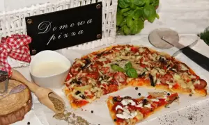 Domowa pizza bez drożdży, z kiełbasą i warzywami, gotowa do podania. Obok sos i przyprawy.