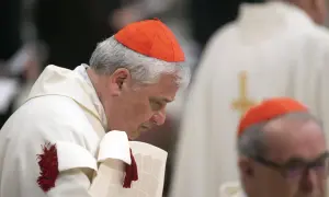 Dwóch kardynałów polskich w czerwonych biretach i białych szatach. Jeden pochyla się nad dokumentem.
