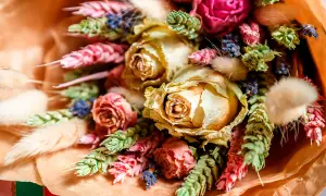 Vacker bukett med torkade rosor, lavendel och andra torkade blommor i varma färger.