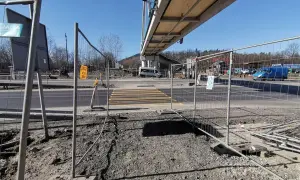 Przejście dla pieszych w budowie, ogrodzone siatką. W tle wiadukt i ruch uliczny. Kmy rejestracja.