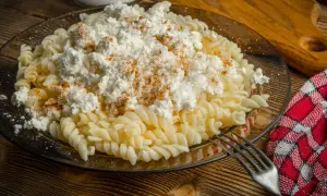 Pyszny obiad z twarogiem na słono: makaron fusilli z dużą porcją białego sera i posypką z papryki.