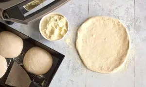 Förberedelser för pizza: poolish pizzadeg, mjöl i skål och degbollar i form.