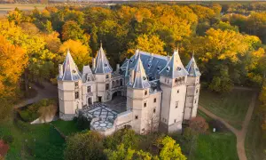Zamek w Gołuchowie otoczony jesiennymi barwami drzew. Malownicza budowla z wieżyczkami i dziedzińcem prezentuje się bajkowo.