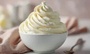 Une délicieuse crème au beurre meringue suisse, aérienne et onctueuse, dressée dans un bol blanc.