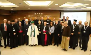 Grupa duchownych i świeckich, w tym muzułmanin w białej szacie, dyskutuje o albania religia.