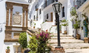 Escaleras empedradas y casas blancas adornadas con flores, un escudo de armas y una farola. Descubre qué ver en Frigiliana, un pueblo blanco andaluz.
