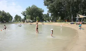 Ludzie kąpią się i bawią na piaszczystej plaży nad jeziorem. Gdzie jest Balaton? Węgry, Szigliget.