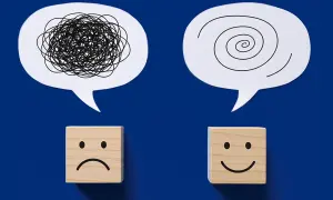 Dwa dymki: jeden z chaotyczną linią, drugi ze spiralą. Pod nimi kostki: smutna i uśmiechnięta. Symbolizują choroby psychosomatyczne i drogę do zdrowia.