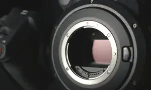 Dettaglio obiettivo di una fotocamera ad alta megapixel, con il pulsante REC visibile.