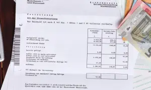 Steuerbescheid mit Geldscheinen. Eine Ratenzahlung ans Finanzamt ist hier nicht direkt ersichtlich, aber das Thema Steuern ist präsent.