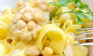 Ciceri e tria, un piatto pugliese con pasta fresca e ceci, guarnito con prezzemolo.