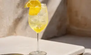 Ett glas med is och en bubblig limoncello drink, garnerad med en citronskiva.