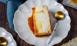 Tranche de flan coco antillais onctueux, nappé de caramel, avec une croûte de noix de coco râpée. Une cuillère dorée est posée à côté.