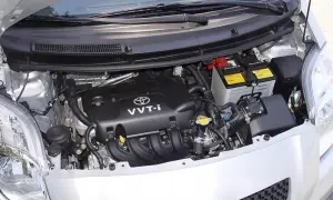 Silnik Toyoty Yaris II z widocznym akumulatorem i elementami osprzętu.