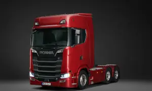 Un puissant camion Scania rouge, modèle V8, prêt pour de longues routes.
