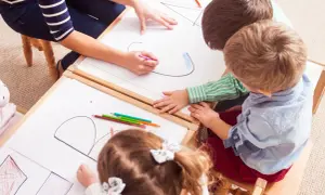 Kinder malen und lernen spielerisch im Kindergarten. Bunte Stifte und viel Kreativität bei den Sprachspielen.