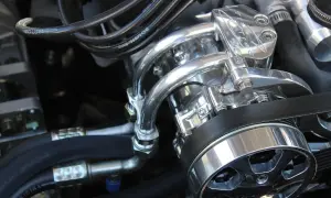 Detalle de un motor con piezas cromadas brillantes y cables. Se escucha un leve traqueteo en el motor, quizás por la tensión de la correa.