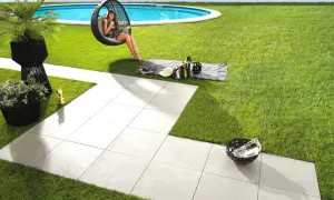 Posa di un pavimento in gres porcellanato con uno spessore ideale per esterni, che crea un'area relax con piscina e vista mare.