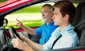 Joven conductor aprende a manejar con su instructor. ¡Con 17 años ya se puede sacar el carnet de conducir!