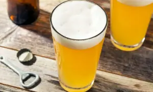 Bicchieri di birra dorata con schiuma bianca, su un tavolo di legno. La gradazione alcolica della birra è un dettaglio importante per gli amanti.