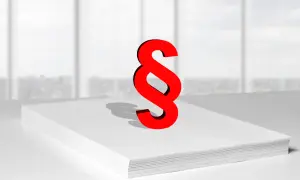 Czerwony znak paragrafu na stercie białych kartek symbolizuje zwięzłe omówienie ustawy o finansach publicznych.