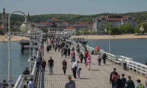 Spacer po molo w Sopocie, gdzie tłumy ludzi korzystają z pięknej pogody. To świetne miejsce na relaks i odkrywanie **Gdańsk atrakcje dla młodzieży**.
