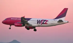 Samolot Wizz Air z różowym dziobem i fioletowym ogonem w locie. Wizz priority to komfort podróży.