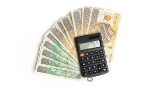 Kalkulator na tle polskich banknotów 100 i 200 zł.