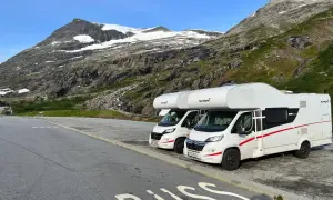 Dwa kampery zaparkowane na tle norweskich gór. Idealne na podróż kamperem w 2 tygodnie po Norwegii.