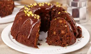 Puszysta babka na oleju, polana czekoladą i posypana pistacjami, kusi swoim wyglądem. Idealna na deser.