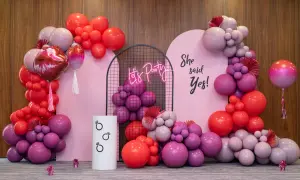Różowa girlanda balonowa tworzy tło dla imprezy. Napis "She said Yes!" i neonowe "Let's Party" dodają uroku.