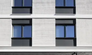 Moderne Fassade mit Klinker und Putz. Fenster mit dunklen Rahmen und blauen Scheiben.