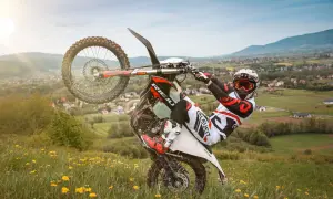 Motocyklista wykonuje jazdę na jednym kole na tle malowniczego krajobrazu. Uważaj, bo taka jazda na jednym kole może skończyć się mandatem!