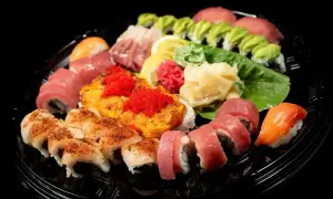 Talerz sushi z różnymi rolkami, nigiri i sashimi. Wyobraź sobie, jak smakuje sushi: świeża ryba, ryż i chrupiące dodatki.